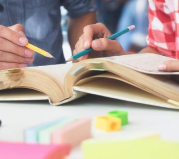 manos-de-jovenes-buscando-informacion-en-libros