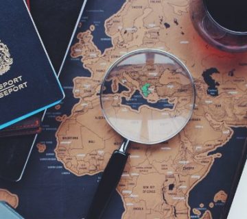 lupa-pasaporte-y-vino-sobre-mapa-del-mundo